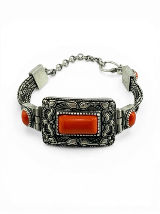 Silver bracelet with red stones on a white background