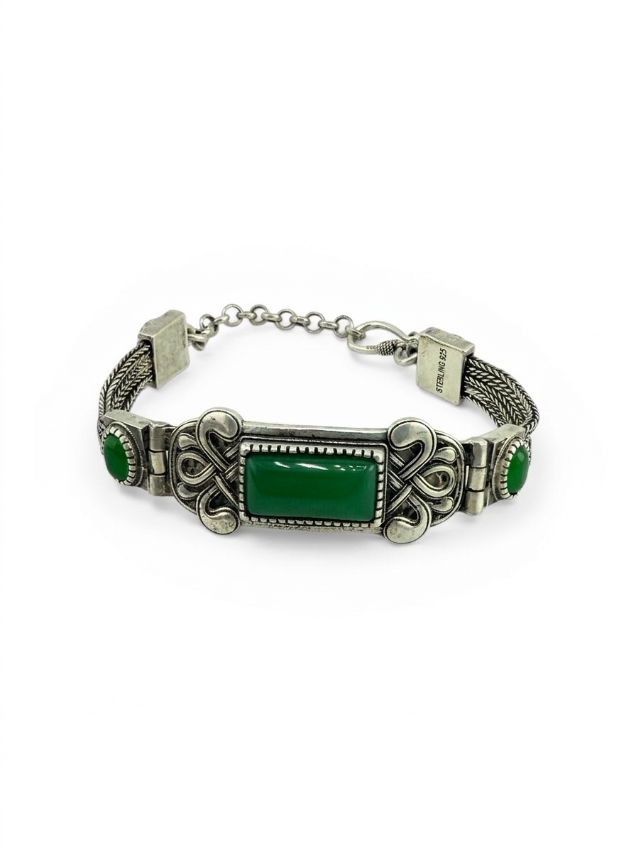 Silver bracelet with green stones on a white background