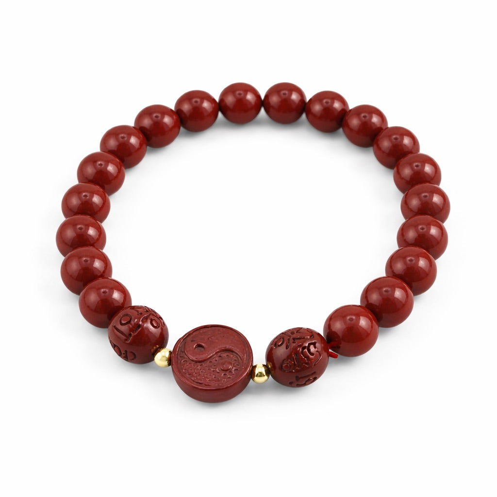Red beaded bracelet with a central yin-yang symbol on a white background