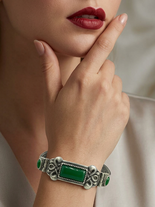 Silver bracelet with green stones on a woman's wrist, close-up shot.