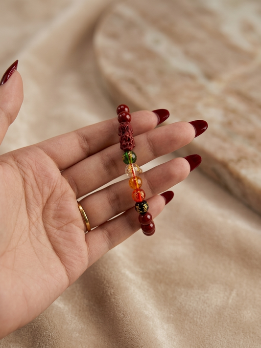 Hand holding a beaded bracelet with a neutral background