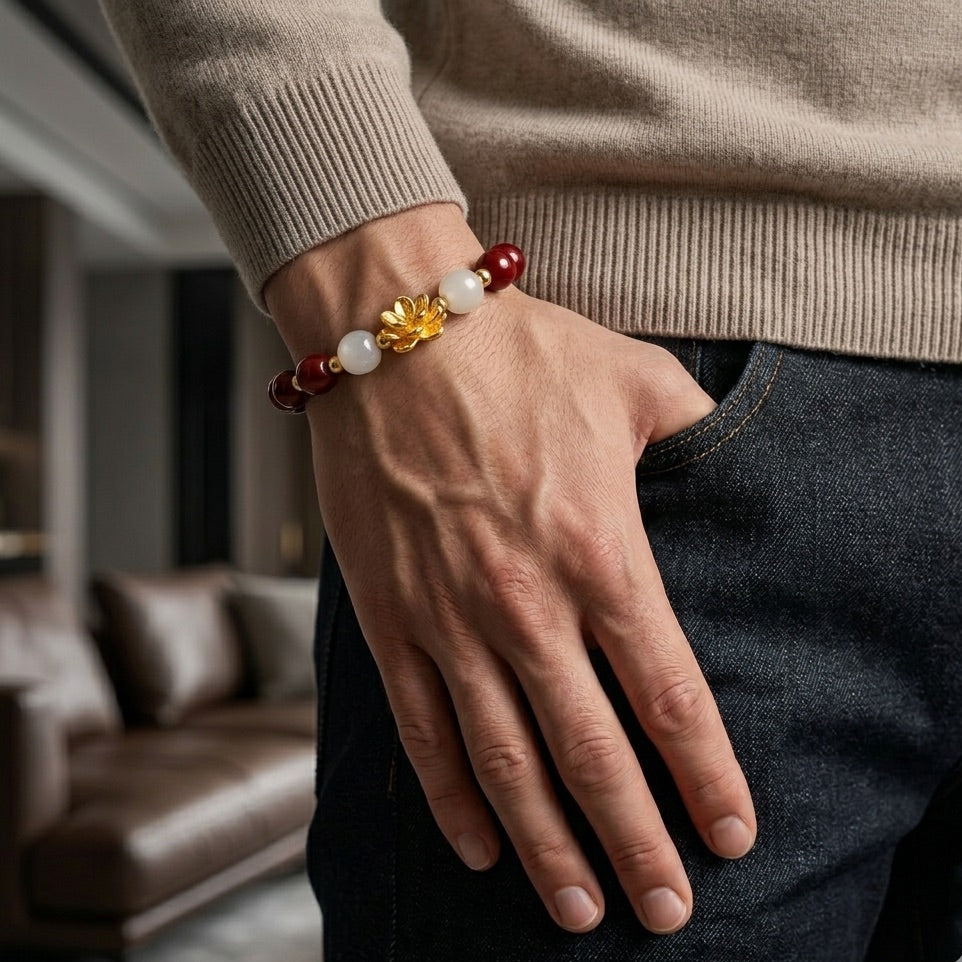 Hand wearing a beaded bracelet with a blurred indoor background