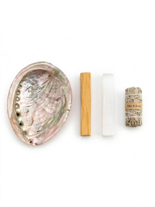 Abalone shell, wooden tool, white stone, and rolled paper on a white background