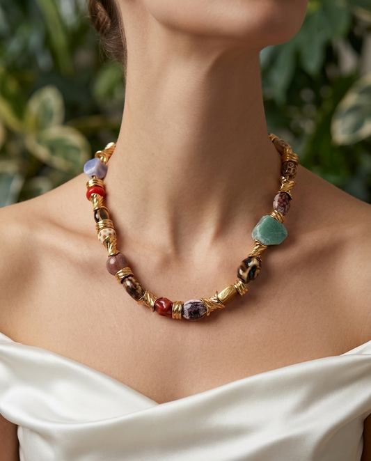 Necklace with multicolored beads worn by a person against a blurred green background