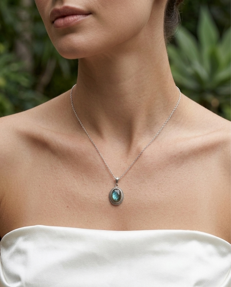 Necklace with a pendant worn by a person against a blurred green background