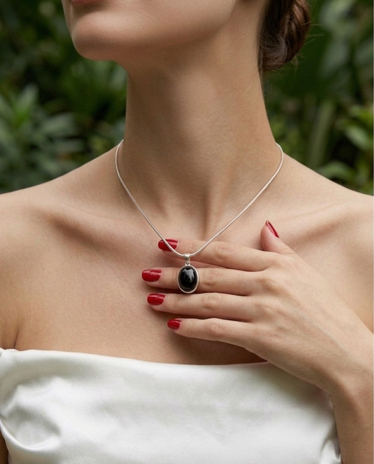 Woman wearing a necklace with a pendant against a blurred green background