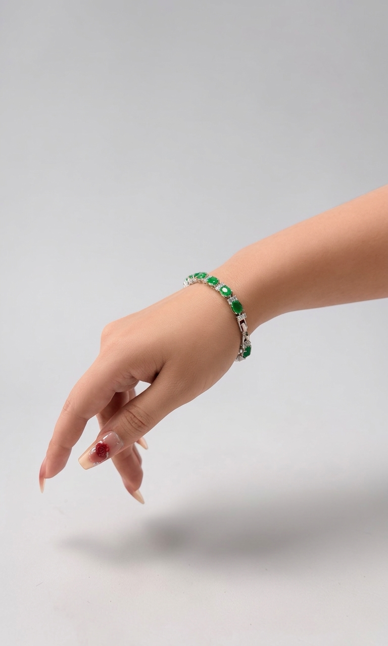 Hand wearing a green bracelet on a light gray background