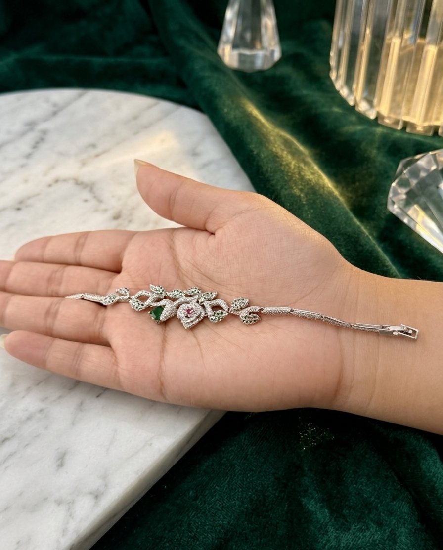 Hand holding a decorative hairpin against a green fabric and marble surface background