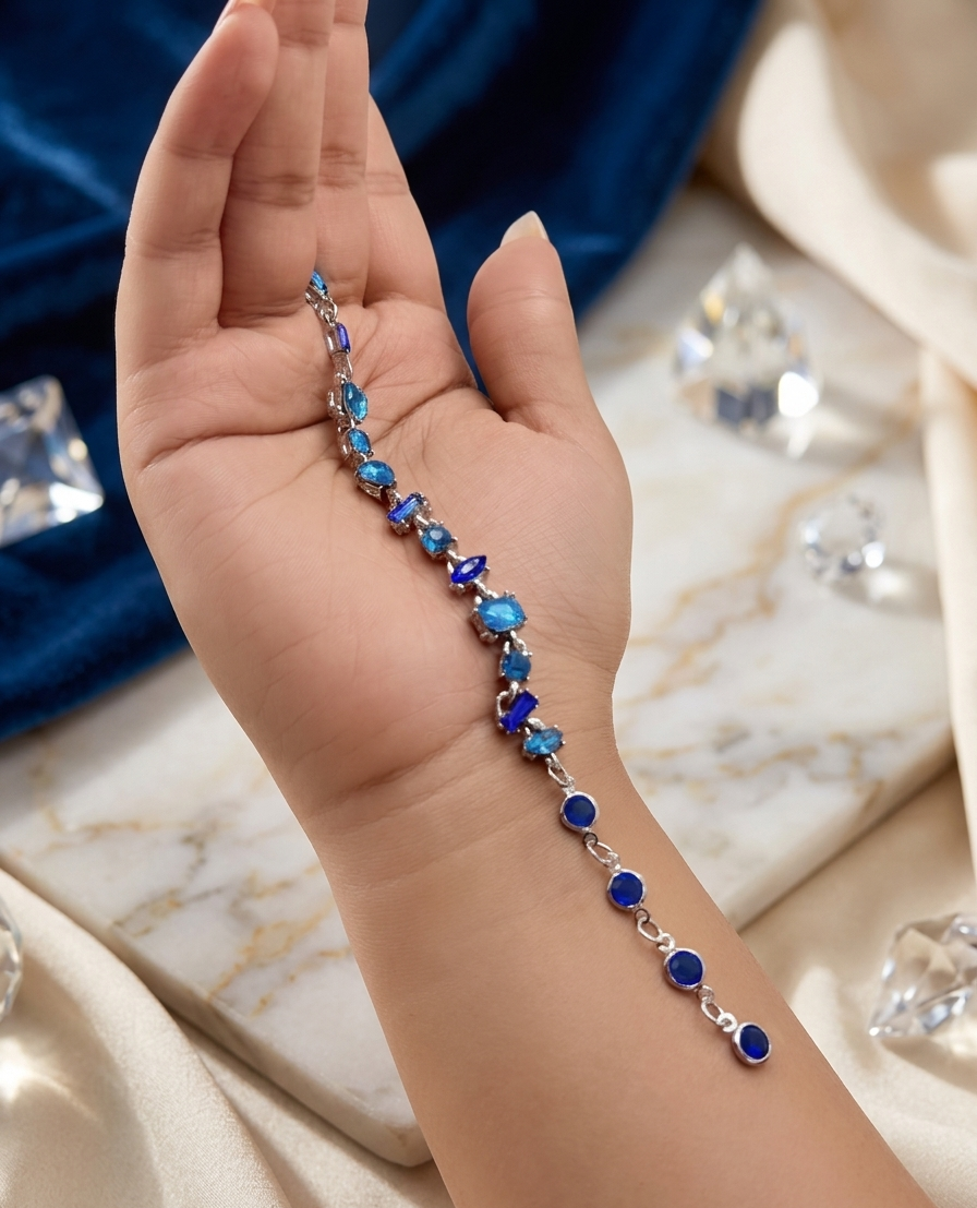 Hand holding a blue beaded bracelet on a marble surface with jewelry in the background