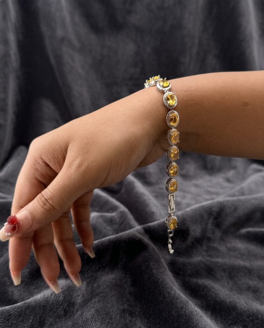 Bracelet with multicolored stones on a wrist against a dark fabric background