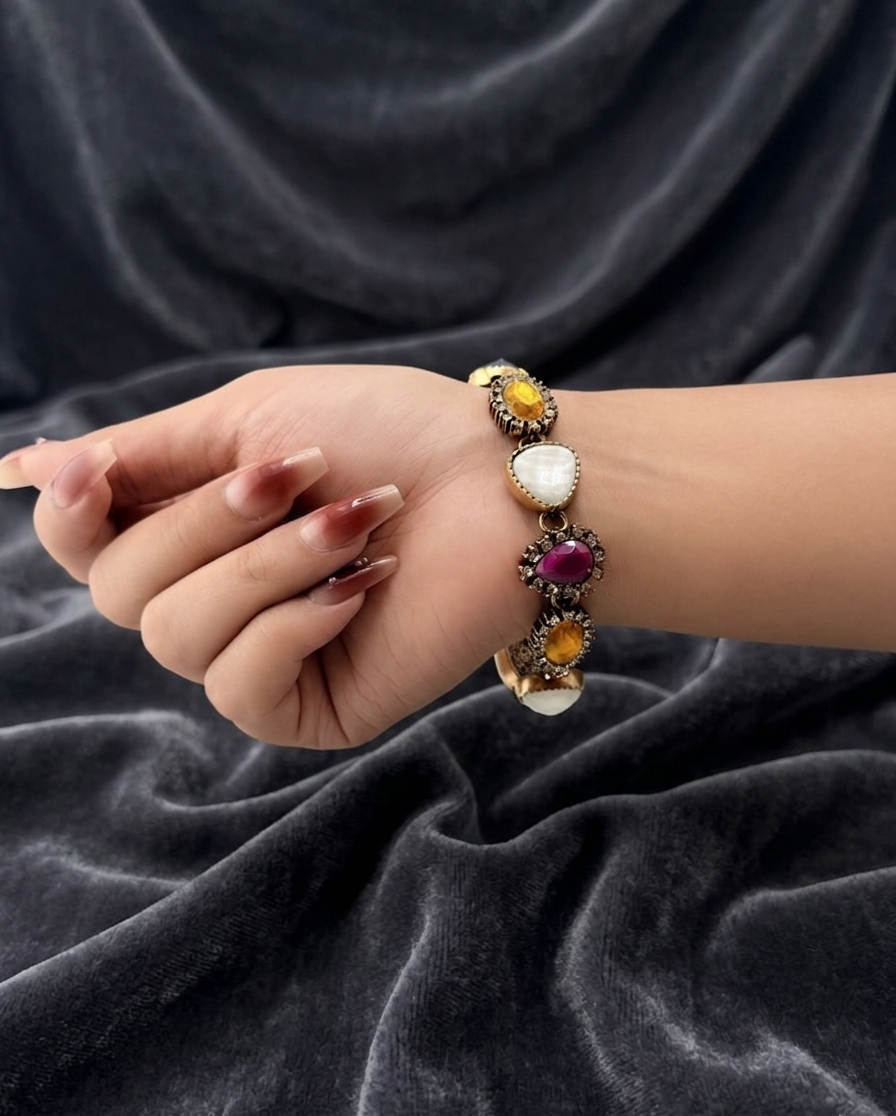 Hand wearing a colorful bracelet on a dark fabric background