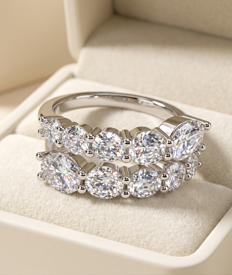 A silver double-row diamond eternity ring displayed inside a cream-colored jewelry box.
