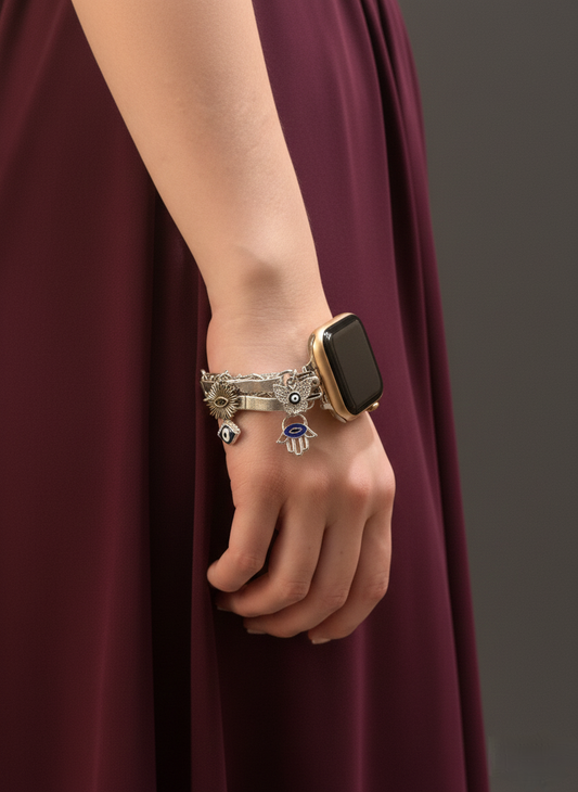 Hand wearing a smartwatch and multiple bracelets against a dark background