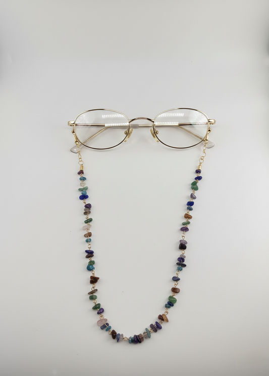 Glasses with a colorful beaded chain on a light gray background