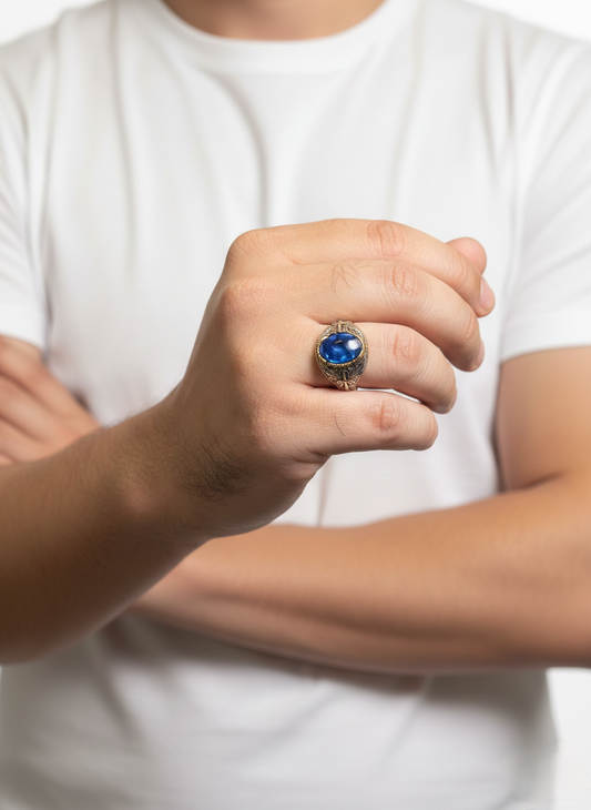 Person wearing a white t-shirt with a blue gemstone ring on a blurred background
