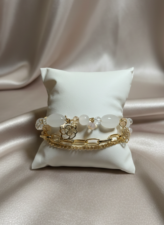Gold bracelet with white stones on a white pillow against a beige fabric background