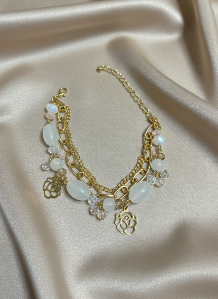 Gold necklace with white stones on a beige satin background