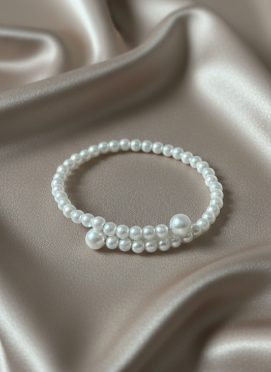 Pearl bracelet on a soft beige fabric background