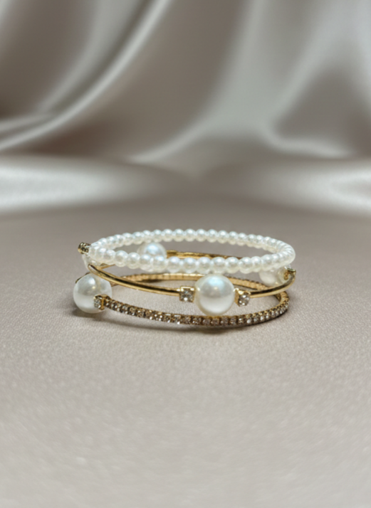 Set of pearl bracelets on a soft fabric background