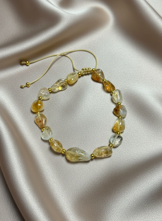 Necklace with yellow and clear beads on a satin surface
