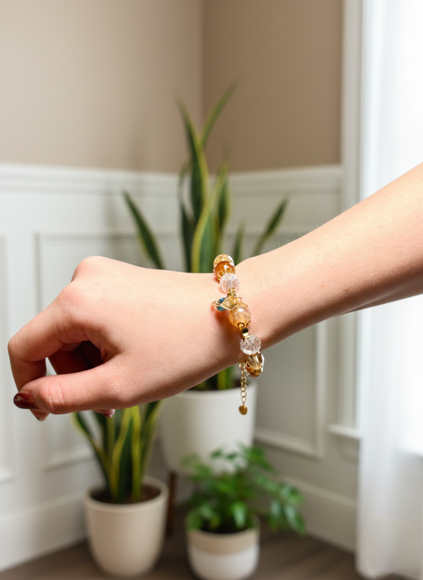 Hand wearing a beaded bracelet with a plant in the background