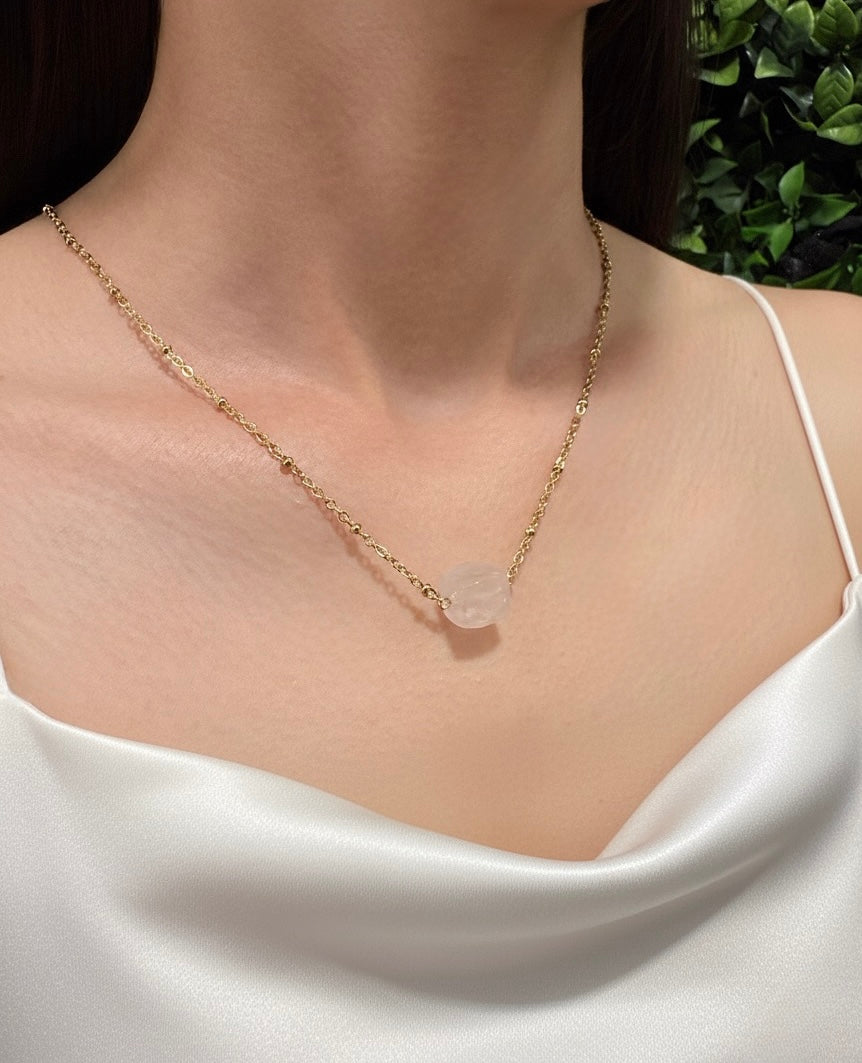 close up rose quartz cube necklace with gold chain
