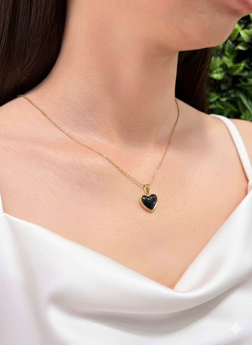 gold plated black obsidian heart pendant displayed on neckline