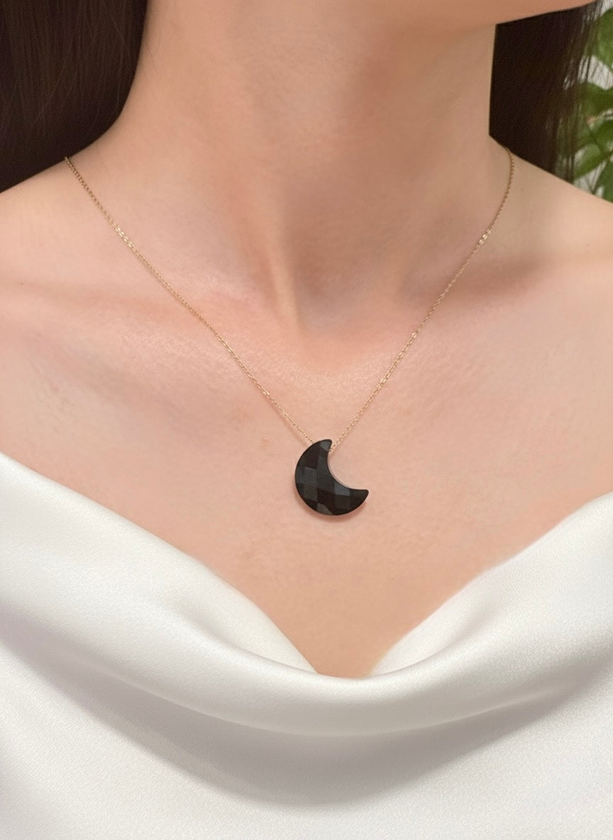 black obsidian crescent moon necklace on model
