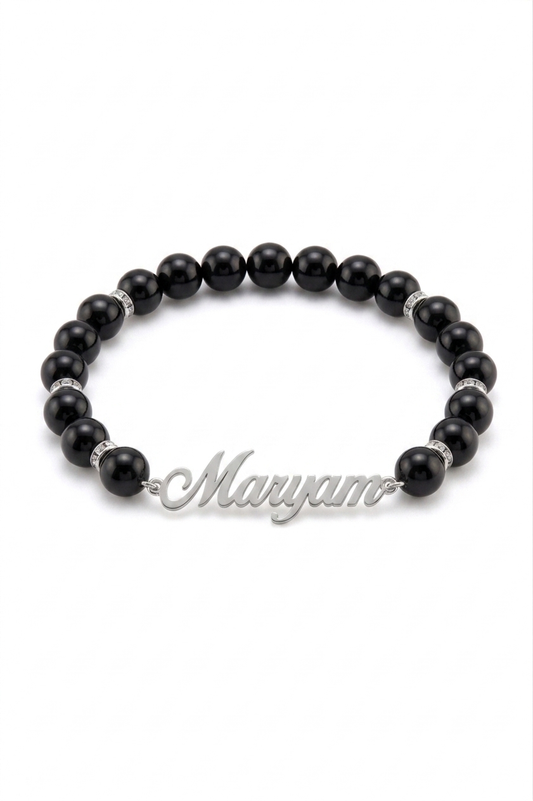 Black beaded bracelet with a silver nameplate on a white background