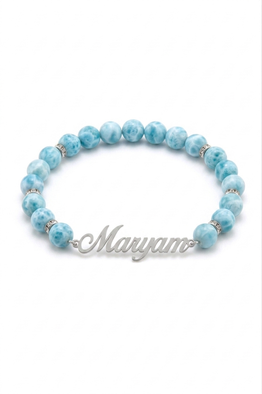 Blue beaded bracelet with a silver nameplate on a white background