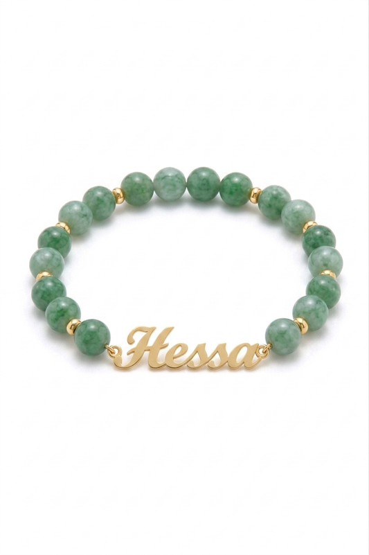 Green beaded bracelet with gold nameplate on a white background