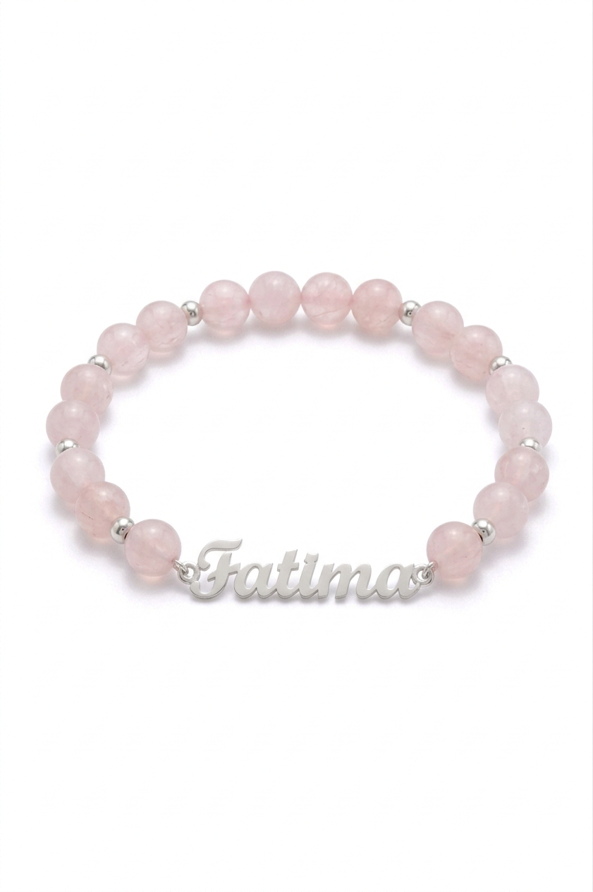 Pink beaded bracelet with 'Fatima' engraving on a white background