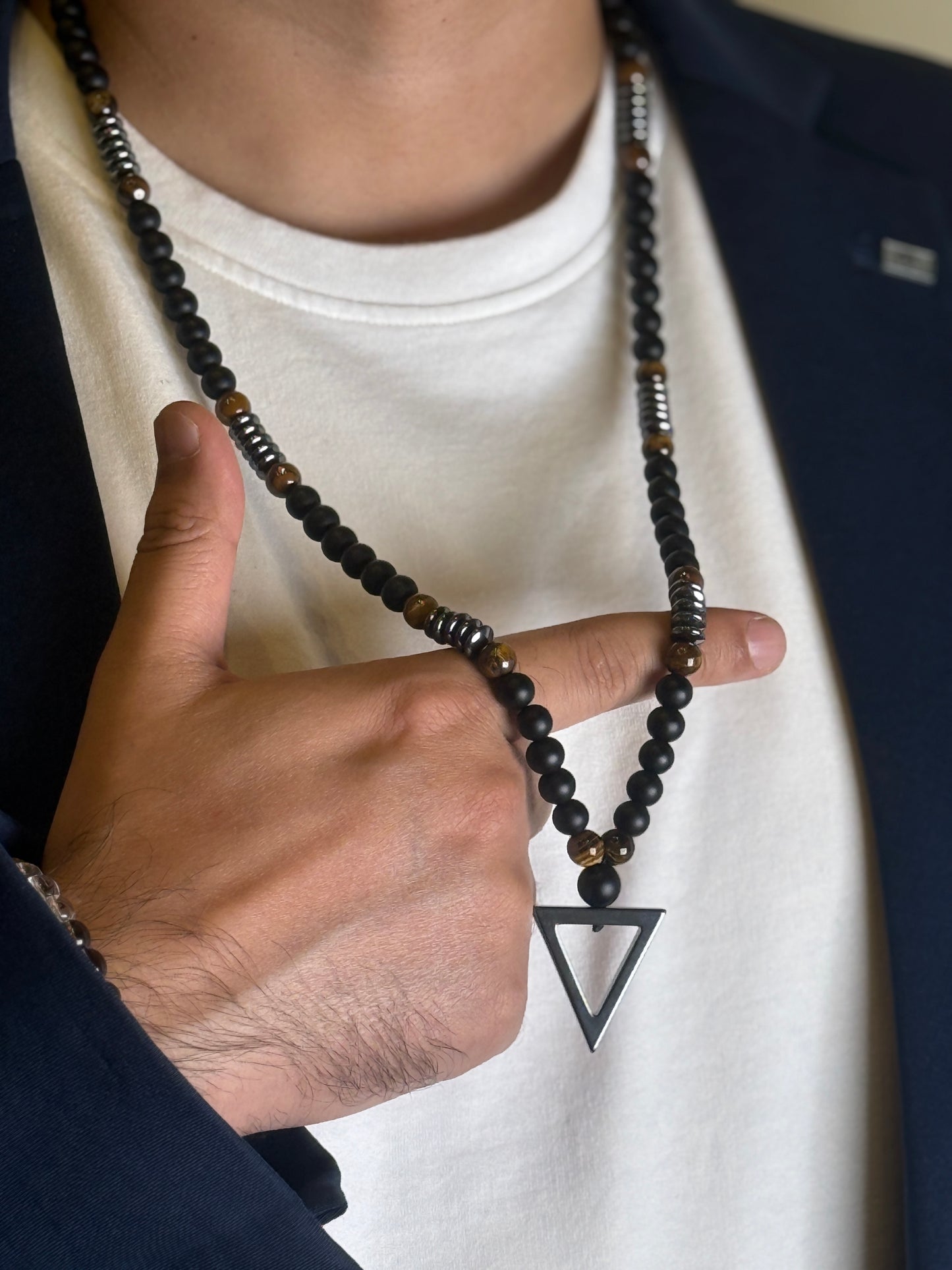 Close-up of Black Matte Onyx Necklace with Triangle Pendant being held