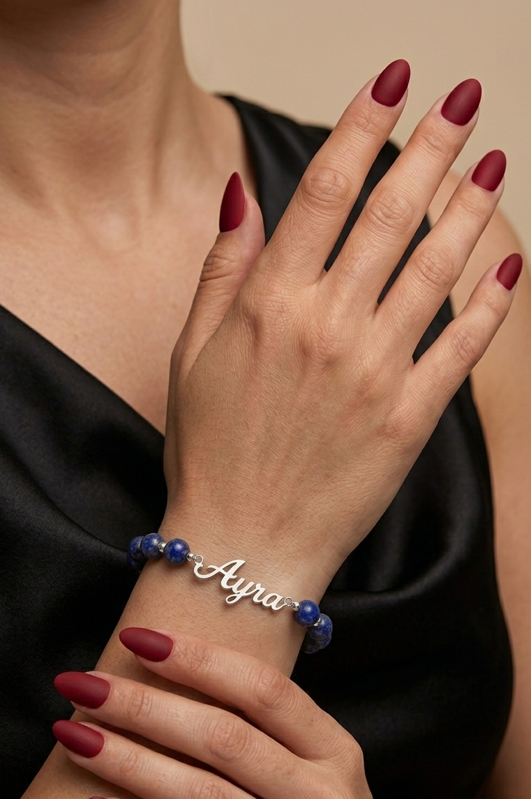 Bracelet with 'Ayla' on a wrist against a neutral background