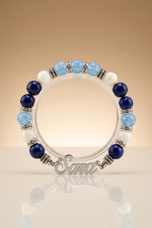Beaded bracelet with 'Santa' charm on a reflective surface with a beige background