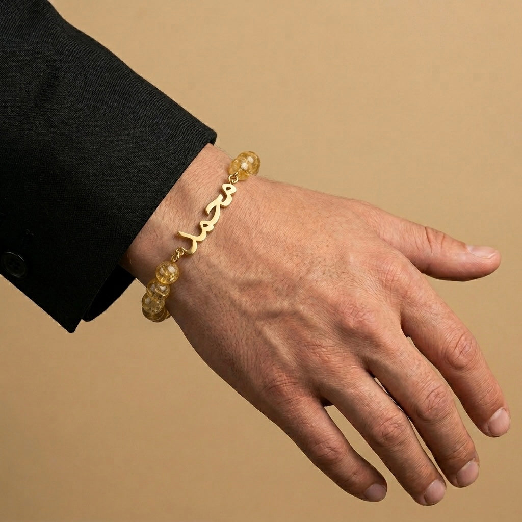 Hand wearing a gold bracelet on a beige background