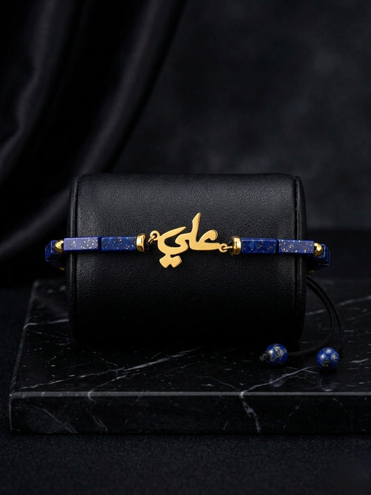 Black handbag with gold and blue jewelry on a dark surface
