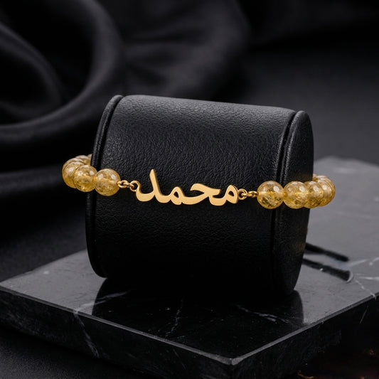 Gold bracelet with beads on a black surface