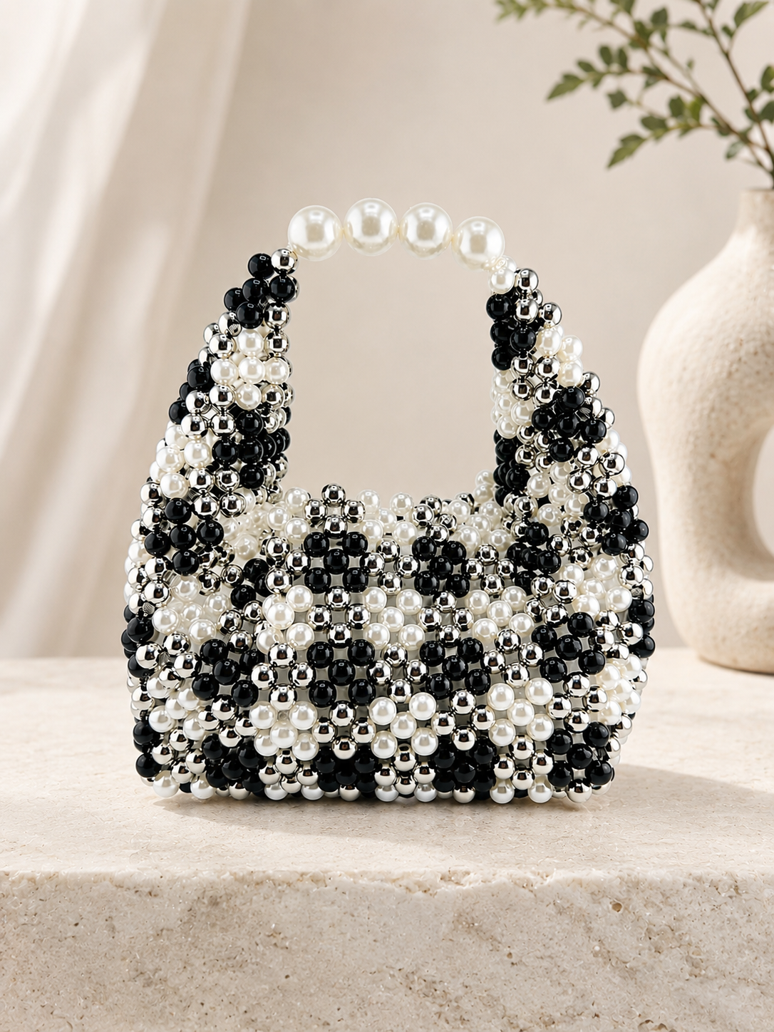 Black and white beaded handbag on a neutral background