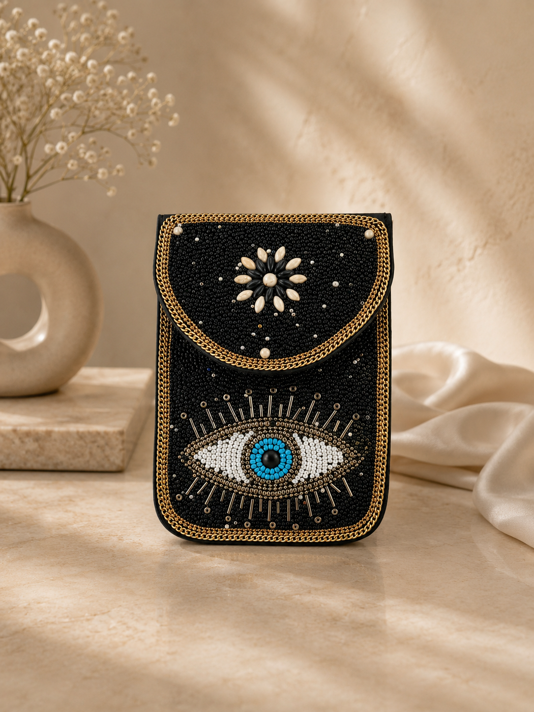 Decorative pouch with eye design on a neutral background