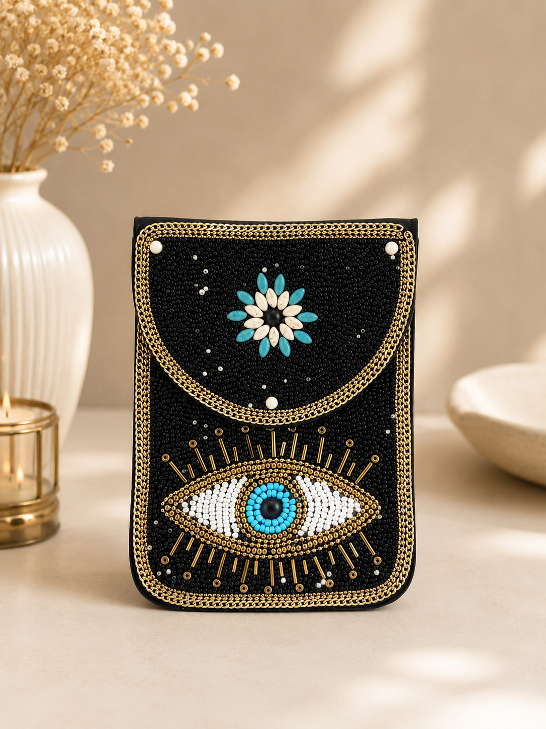 Decorative phone case with eye and floral design on a neutral background