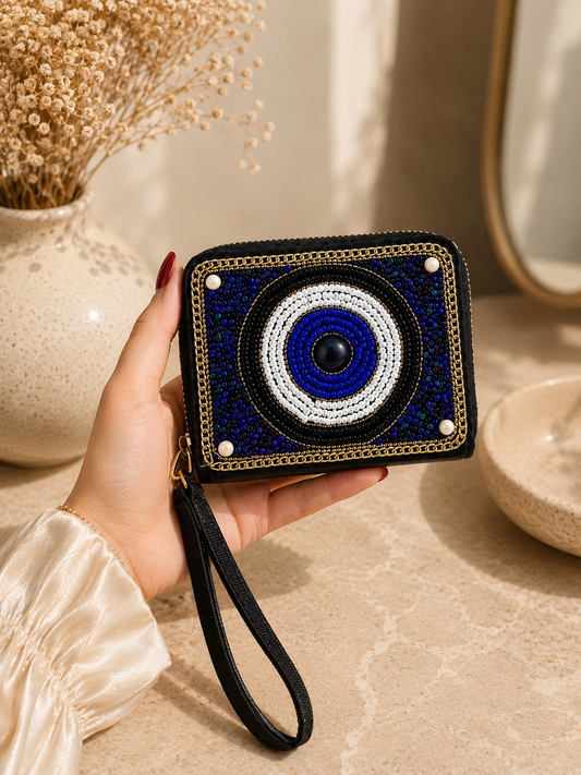 Hand holding a decorative wallet with a blue and white design, placed on a neutral surface.