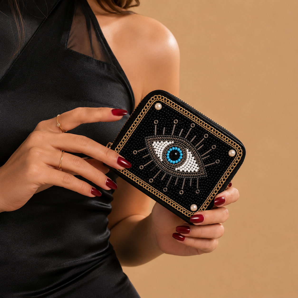 Black wallet with eye design held by a person against a beige background