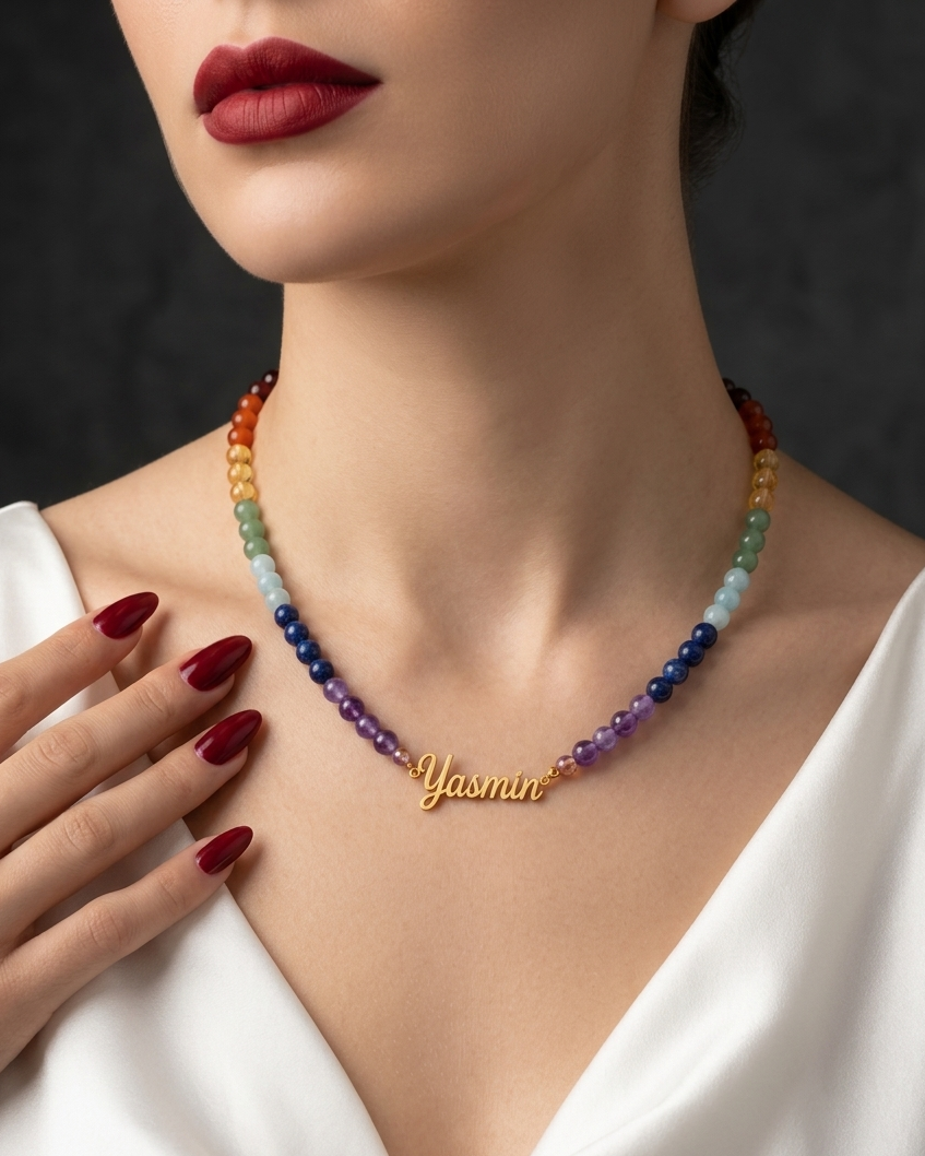 Close-up of a person wearing a colorful beaded necklace with a gold nameplate and red lipstick.