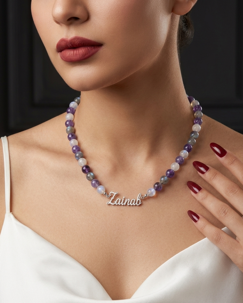 Necklace with 'Zainab' pendant on a model against a black background