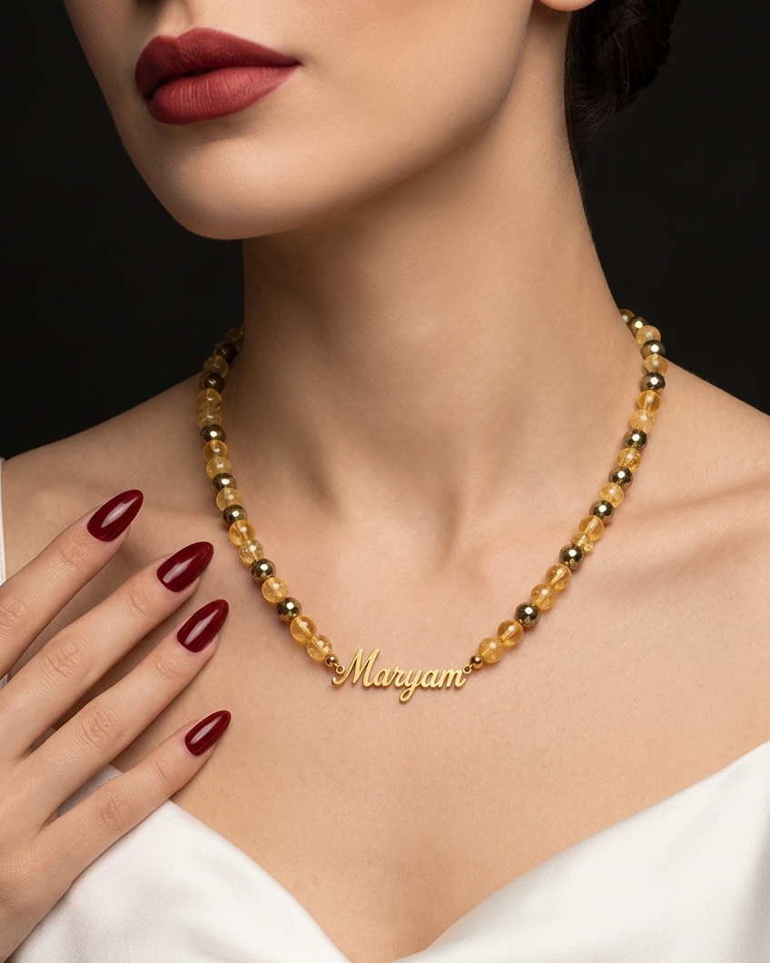 Necklace with 'Maryam' nameplate worn by a model with red lipstick and nail polish.