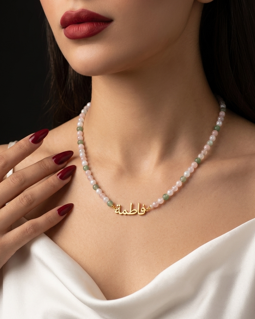 Necklace with a gold pendant worn by a model with red lipstick and white top.