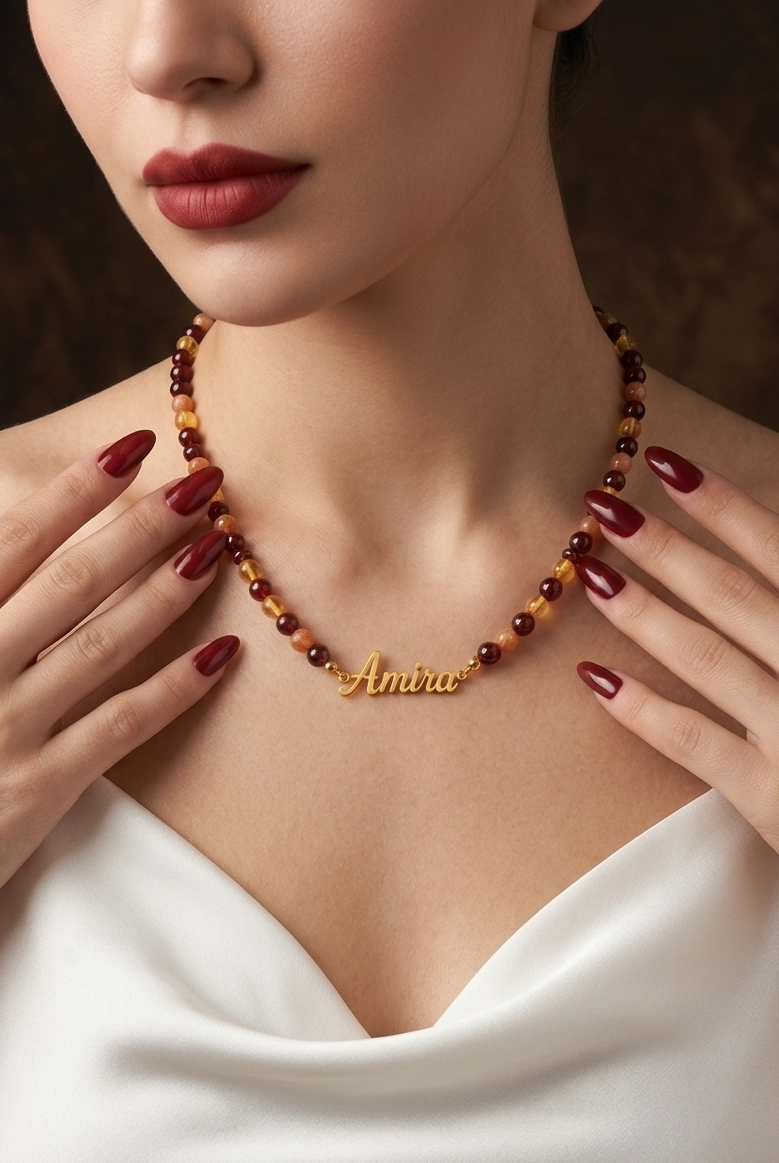 Woman wearing a beaded necklace with 'Amira' engraving, close-up of neck and hands.