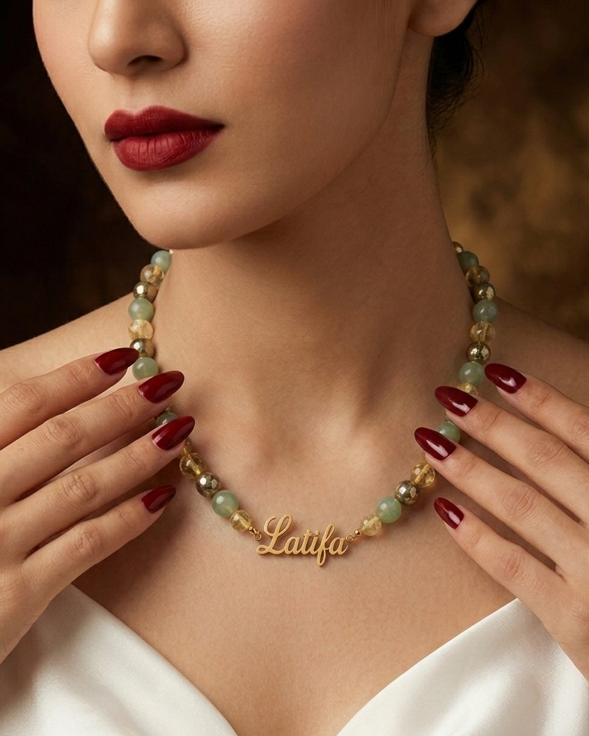 Woman wearing a gold necklace with 'Latifa' engraving, against a blurred background.