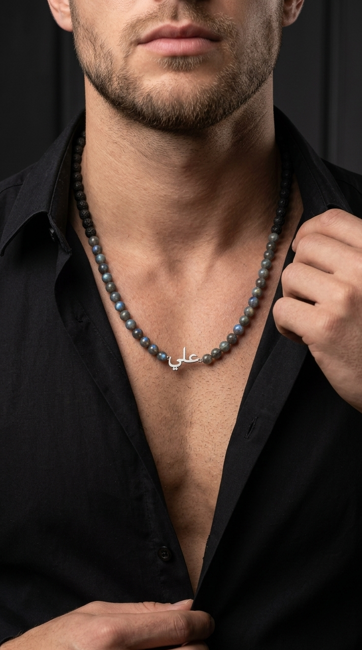Man wearing a black shirt with a necklace featuring Arabic script.
